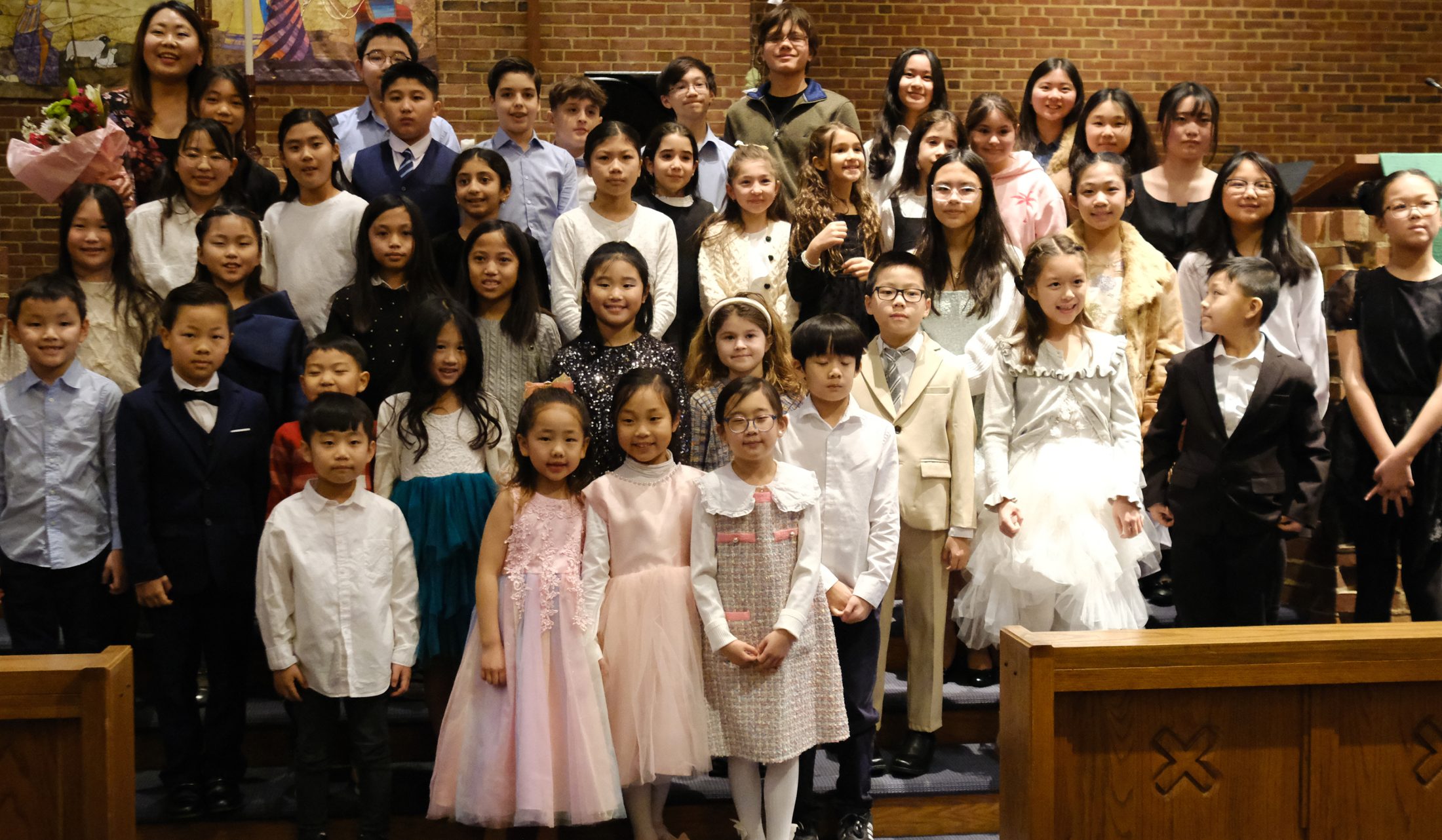 Yoonjoo with her students, dressed up on stage after a studio recital